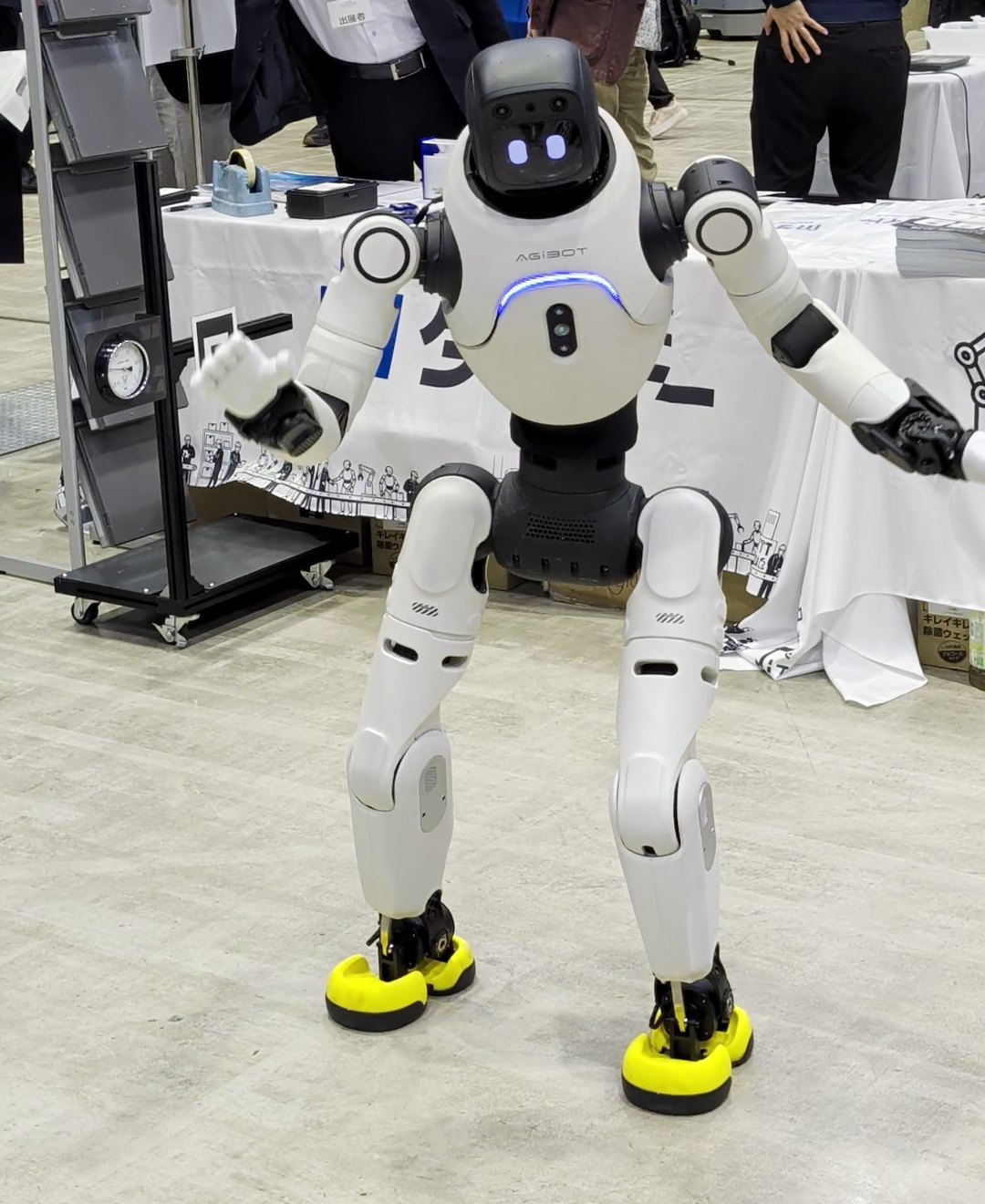 腕を広げて踊る白い人型ロボット