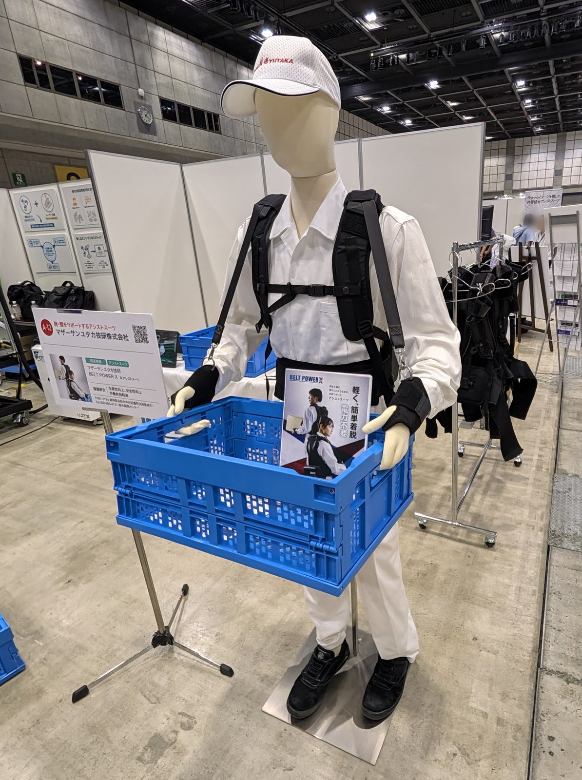 アシストスーツを着たマネキンが折りたたみコンテナを持つ展示